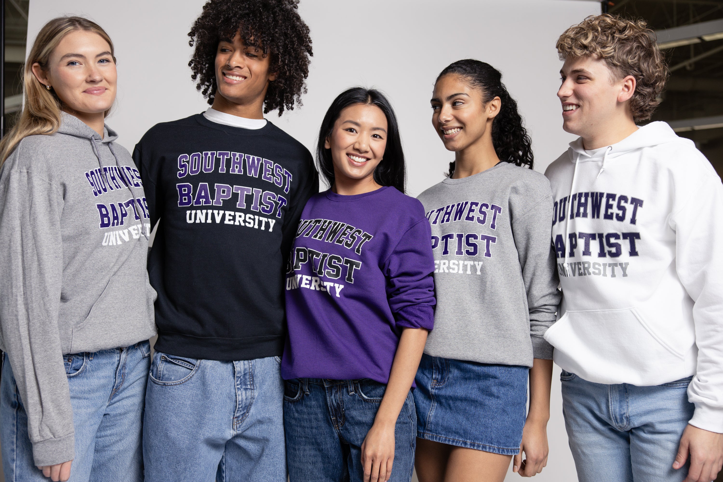 Group of people wearing Southwest Baptist University sweatshirts in various colors.