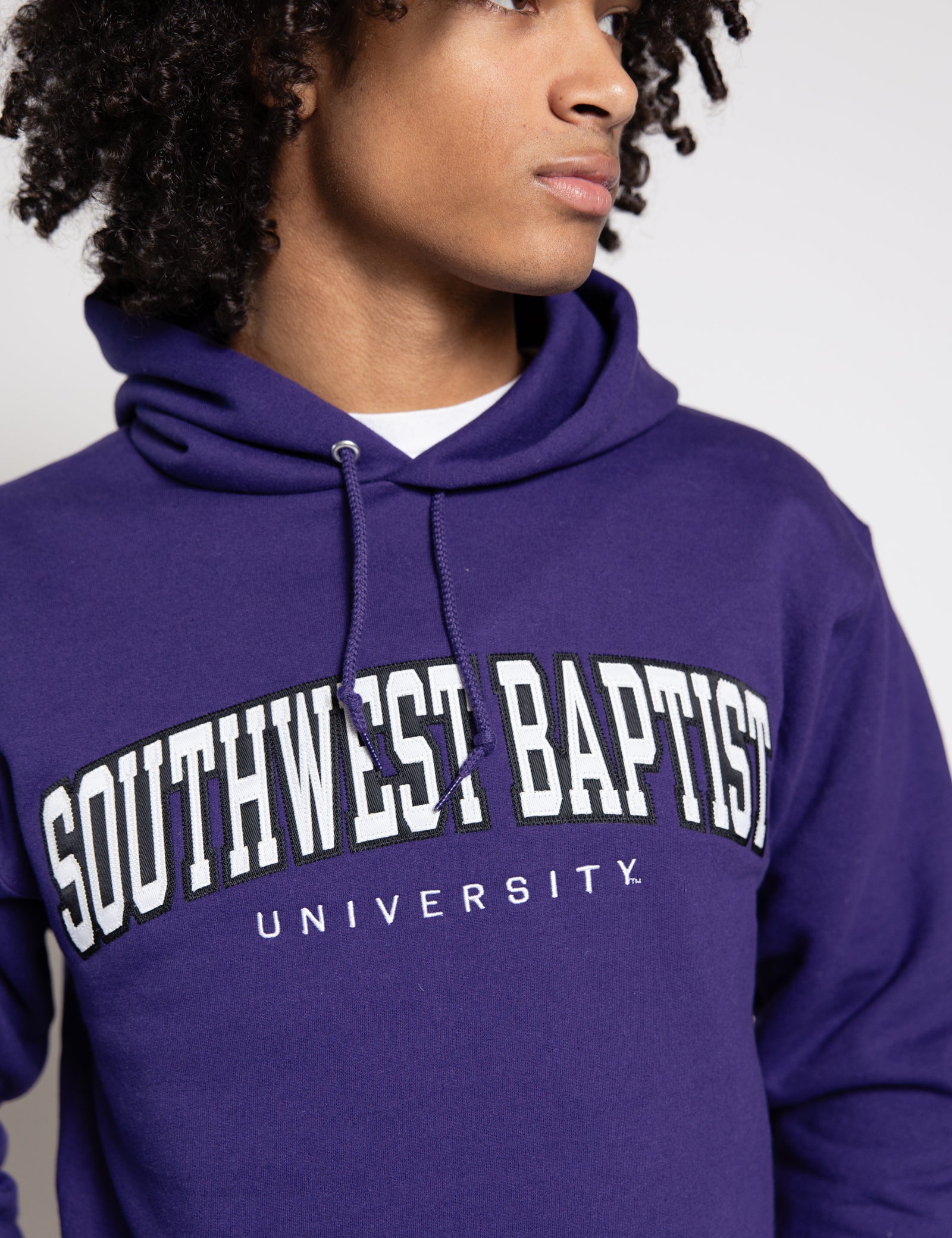 Male wearing a purple hoodie with 'Southwest Baptist University' text