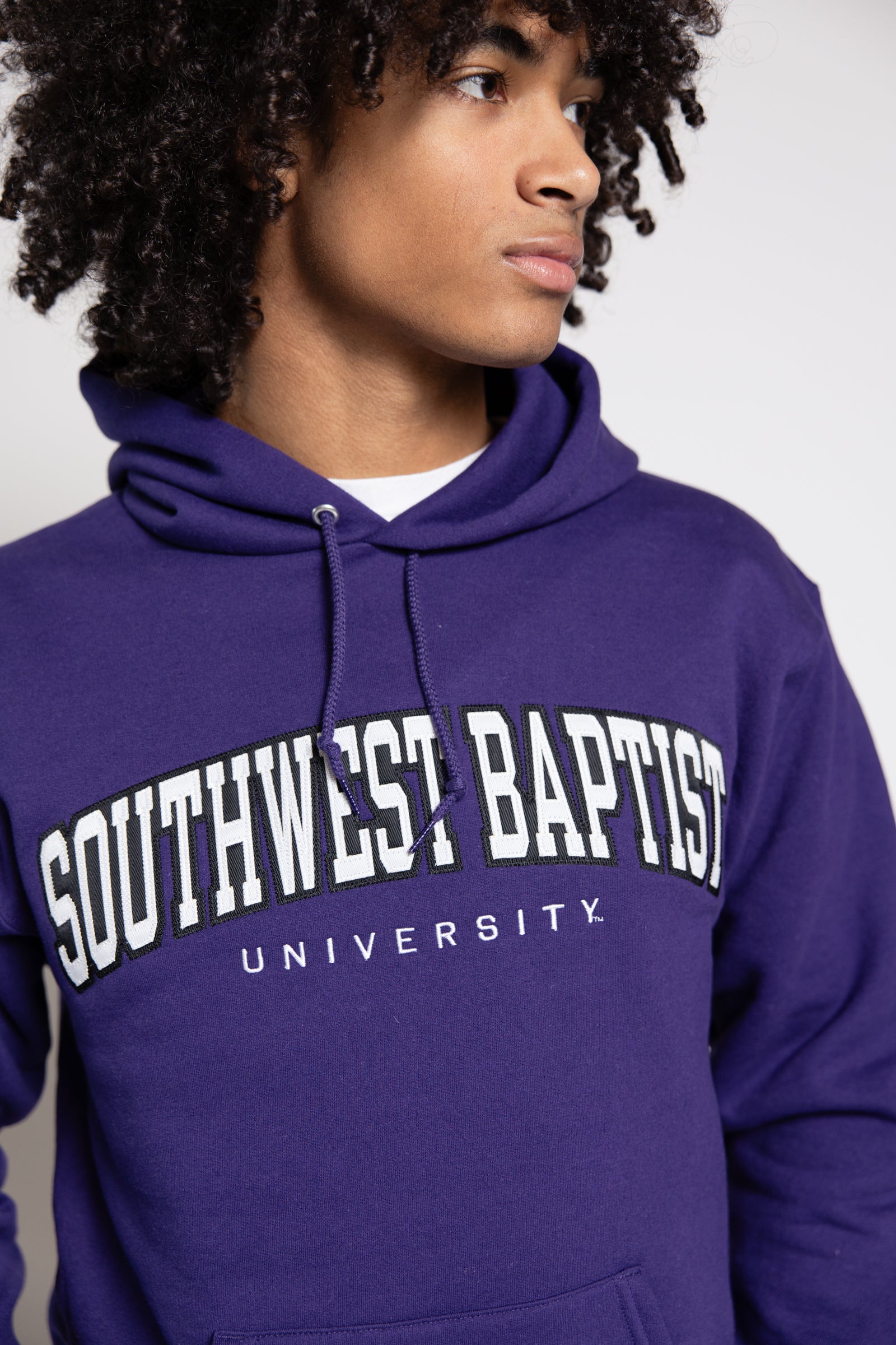 Male wearing a purple hoodie with 'Southwest Baptist University' text
